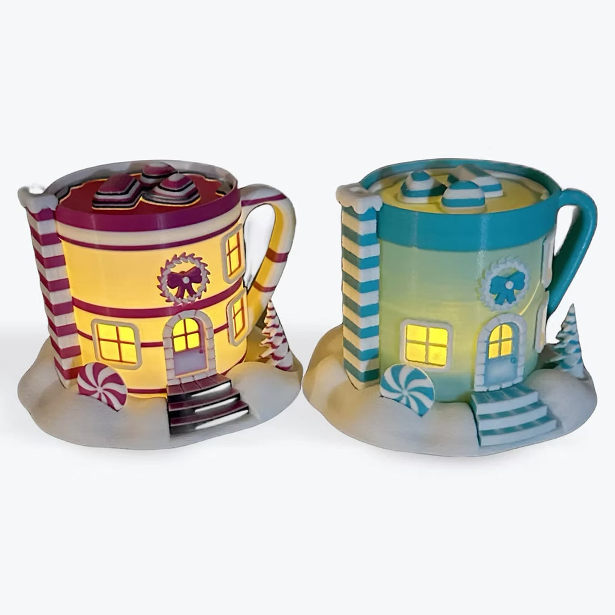 Two hot cocoa cottage lanterns glowing, pink and teal