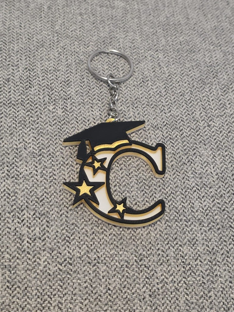 Graduation letter C keychain with a black cap and gold stars