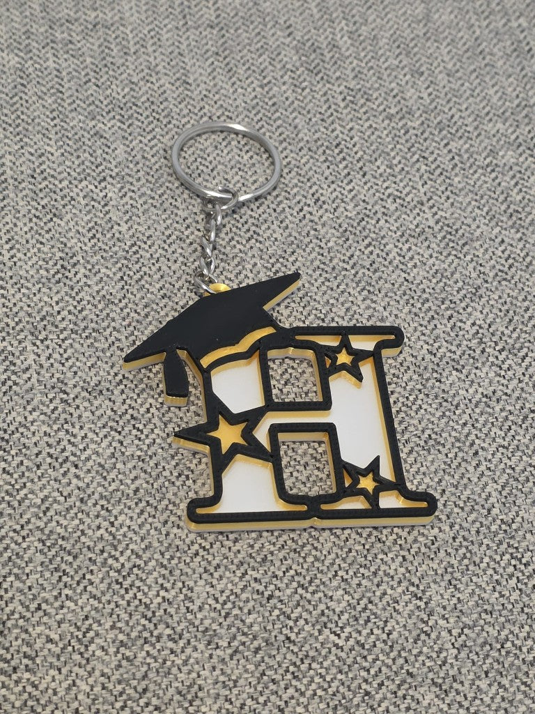 Graduation letter H keychain with a black cap and gold stars